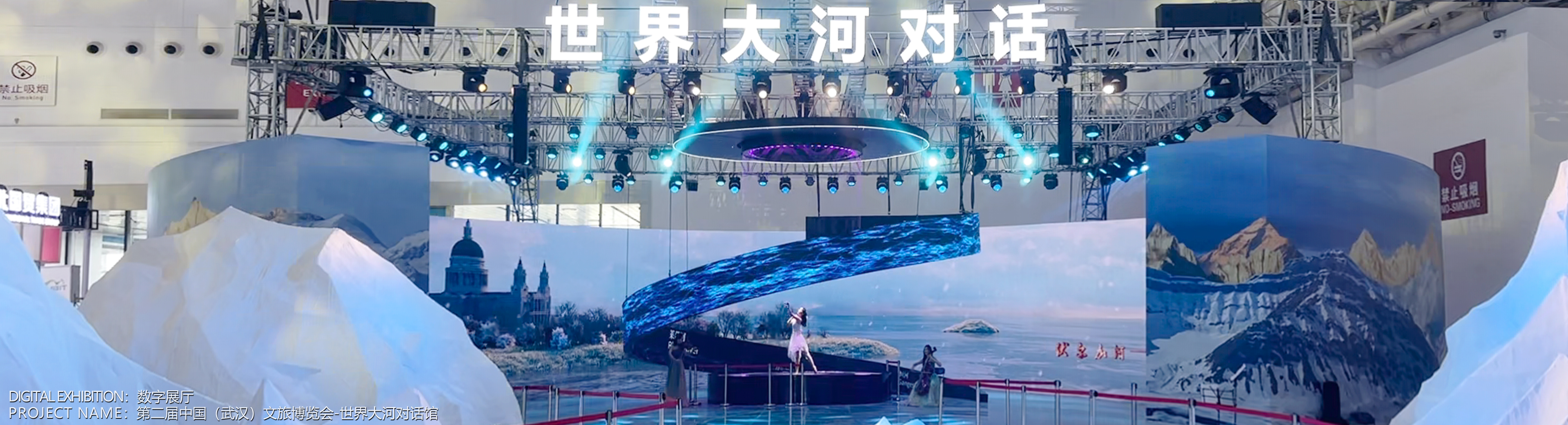 数字空间主视觉 02:展馆现场的冰雪主题舞台与螺旋屏幕,顶部悬挂世界大河对话字样,底部标注数字展厅·第二届中国(武汉)文旅博览会世界大河对话馆